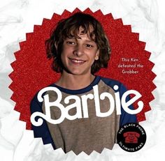 a young man smiling in front of a red circle with the word barbie on it