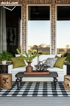 a white couch sitting on top of a black and white checkered floor next to windows