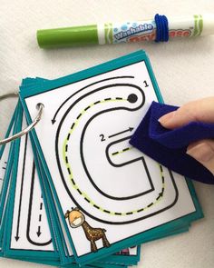 a hand is stamping out the letter s on top of several cards with markers