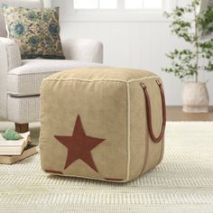 a brown and red star ottoman sitting on top of a rug next to a white chair