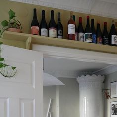 there are many bottles on the shelf above the door