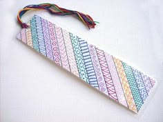 a piece of paper with colorful designs on it and a string hanging from the end