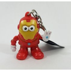 a red and yellow toy character holding a pair of scissors in it's hand