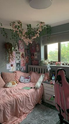 a bedroom with pink bedding and lots of plants hanging from the ceiling