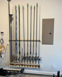 there are many skis and poles hanging on the wall in front of an electrical outlet