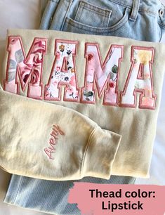 a pair of jeans with the word mama on them next to an embroidered t - shirt