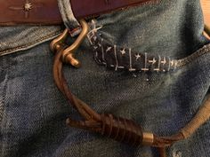 a pair of jeans that have been pinned to the back of their pants with leather straps