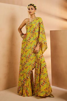 Yellow botanical print one shoulder kaftan top features hand embroidered neckline, cowry shells and coin detailed hemline. Comes with matching printed gharara.
Components: 2
Pattern: Printed, Embroidered
Type Of Work: Botanical, Shells
Neckline: One Shoulder
Sleeve Type: One Shoulder Batwing
Fabric: Crepe
Color: Yellow
Other Details: 
Asymmetric hem kaftan top
Note: All the jewellery worn by the model is not for sale
Occasion: Mehendi and Haldi - Aza Fashions One Shoulder Kaftan, Kaftan Pattern, Kurti Styles, Silk Anarkali Suits, Haldi Outfits, Silk Anarkali, Kaftan Top, Indian Dress, Embroidered Neckline