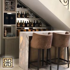 three bar stools in front of a counter with bottles on it