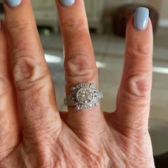 a woman's hand with a ring on it and a blue manicured nail polish