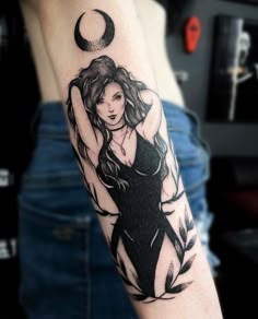 a woman's arm with a tattoo on it and the moon above her head