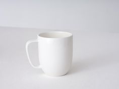 a white coffee cup sitting on top of a table