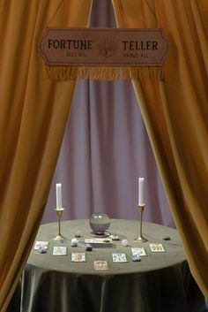 a table with candles and pictures on it under a sign that says fortine teller