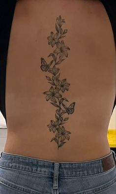 Spine tattoo Spine Tattoo With Flowers And Butterflies, Spine Tattoos Hummingbird, Flower Tattoos Spine Simple, Floral Butterfly Spine Tattoo, Tattoo Ideas Female Meaningful Spine, Spine Tattoo Butterfly Flowers, Spine Tattoos Butterflies And Flowers, Waterlily Spine Tattoo, Cute Simple Spine Tattoos For Women