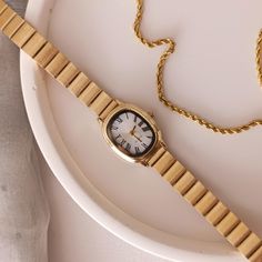 ➡ Product Features: 📏 Case Diameter 20*25 mm ⌚ Suitable for daily use 💪  Steel case ⚙️ Quartz mechanism. 💎 Mineral glass is used. ✈Free shipping. -Timeless elegance meets modern charm in our exquisite Gold Colour Minimal Wrist Watch for Women. This stunning timepiece is a true embodiment of sophistication, featuring a lustrous white dial adorned with delicate Roman numerals, reminiscent of bygone eras. Crafted to perfection, the adjustable band ensures a comfortable and customized fit, allowi Adjustable Gold Watch With Round Dial, Vintage Gold Watch Accessories For Everyday, Gold Stainless Steel Watch Accessories For Everyday, Everyday Watch Accessories With Bracelet Strap And Round Dial, Timeless Adjustable Watch Accessories For Gift, Timeless Adjustable Watch Accessories As Gift, Present For Her, Watch For Women, Presents For Her