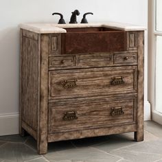 a bathroom vanity with two faucets on the top and one drawer below it