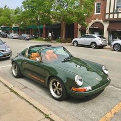 a green sports car is parked on the side of the road