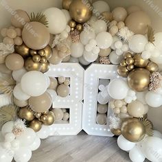 the balloon arch is decorated with gold and white balloons