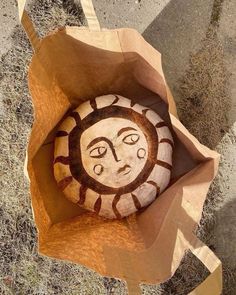 a paper bag with a painted rock in it