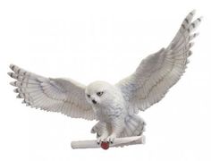 a white owl figurine holding a baseball bat