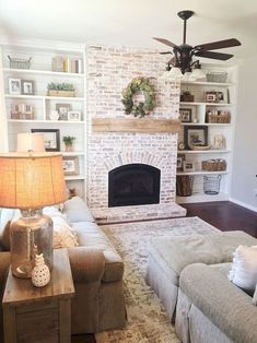 a living room filled with furniture and a fire place in front of a brick fireplace