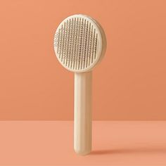 a hair brush sitting on top of a pink surface