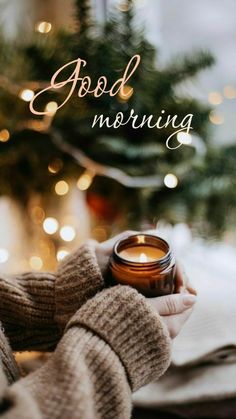 a person holding a candle in their hands with the words good morning on top of it