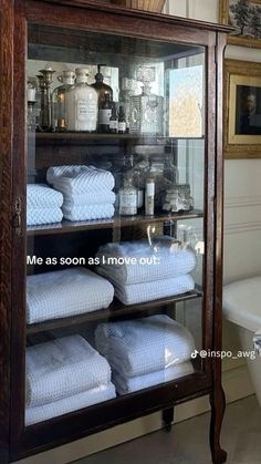 a display case filled with lots of white towels in a bathroom next to a tub