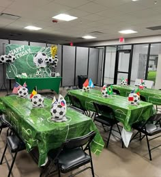 soccer themed tables and chairs are set up in an office setting with green tablecloths