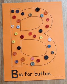 the letter b is for button on an orange paper with black and white buttons in it