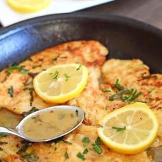 a pan filled with chicken and lemon slices