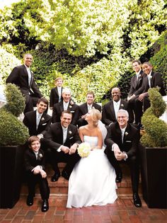 a bride and groom posing for a photo with their wedding party in front of them