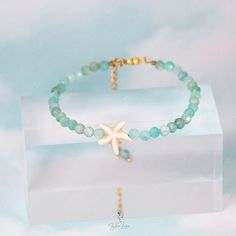 This stunning bracelet showcases a 4.2 mm faceted Mozambique Amazonite bead surrounded by stainless steel wire to maintain its perfectly round shape. A charming starfish bead adds an eye-catching accent to the design. Enjoy a secure and comfortable fit with the adjustable 5 cm stainless steel chain.Bracelet length: 18 cm + 5 cm adjustable chain Bead diameter: 4.2 mm Materials: Amazonite, stainless steel Jewelry Care: See more information about how to care for your jewelry here. Shipping Policy: Silver Starfish Beaded Bracelet Gift, Silver Starfish Shaped Beaded Bracelet Gift, Turquoise Bracelet With Starfish Charm As Gift, Adjustable Beaded Bracelet With Starfish Charm As Gift, Adjustable Starfish Charm Bracelet Gift, Adjustable Star Crystal Bracelet Gift, Adjustable Star Crystal Bracelet As Gift, Adjustable Star Crystal Bracelet For Gifts, Adjustable Star-shaped Crystal Bracelet Gift