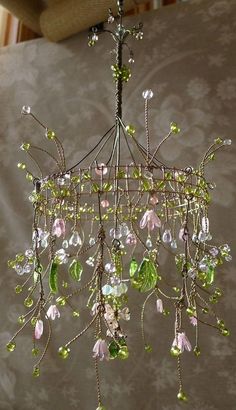 a chandelier with green and pink flowers hanging from it