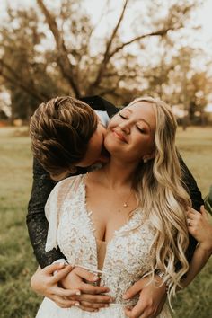 a bride and groom kissing in a field