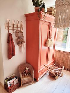 a baby crib in the corner of a room next to a wall with hooks on it