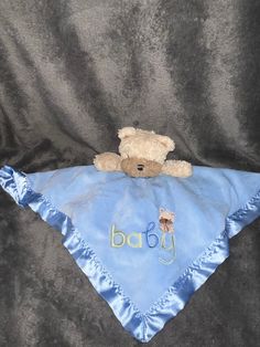 a teddy bear laying on top of a blue blanket