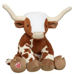 a brown and white stuffed cow sitting down