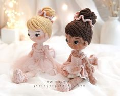 two crocheted dolls sitting on top of a white bed next to each other