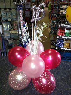 balloons and streamers are arranged in a vase