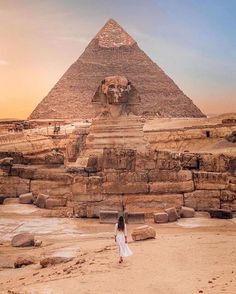 a woman standing in front of the pyramids at giza