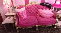 a pink couch with pillows on it in a room decorated for barbie's birthday