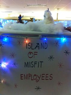 a sign that says island of misfit employees with lights around it and people in the background