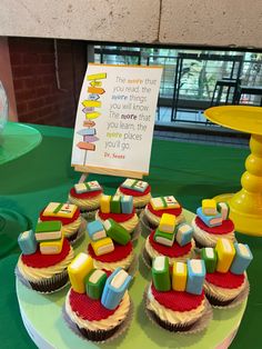 cupcakes are arranged on a table with a sign