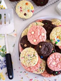 a plate full of cookies with sprinkles next to a knife and fork