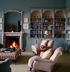 a living room filled with furniture and a fire place in the middle of a room