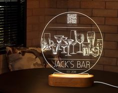 an illuminated bar sign with wine glasses on it and the name jack's bar