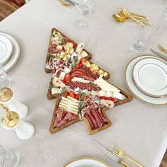 a star shaped platter with meats, cheese and fruit on it sits on a table