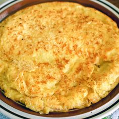 an omelet in a brown and white dish on a table