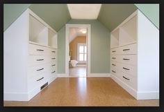 an empty hallway with white drawers and green walls